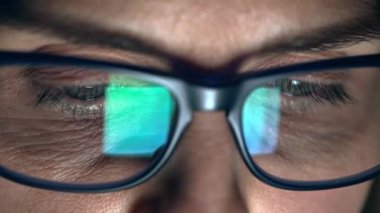 Yetişkin bir kadının evdeki oturma odasında kanepede otururken dijital tablette kitap okuduğu bir video..