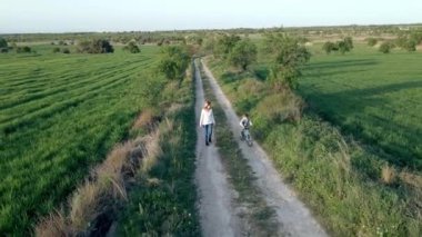 Anne ve oğlunun doğada bisiklet sürerken ve yürürken videosu..