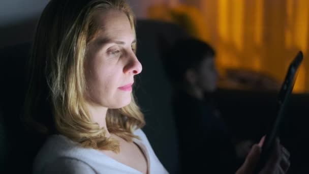 Wideo Dojrzałą Kobietą Czytającą Tablecie Cyfrowym Podczas Siedzenia Kanapie Salonie — Wideo stockowe