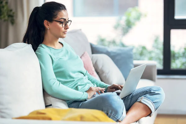Tiro Jovem Mulher Confiante Trabalhando Com Seu Laptop Sentado Sofá — Fotografia de Stock