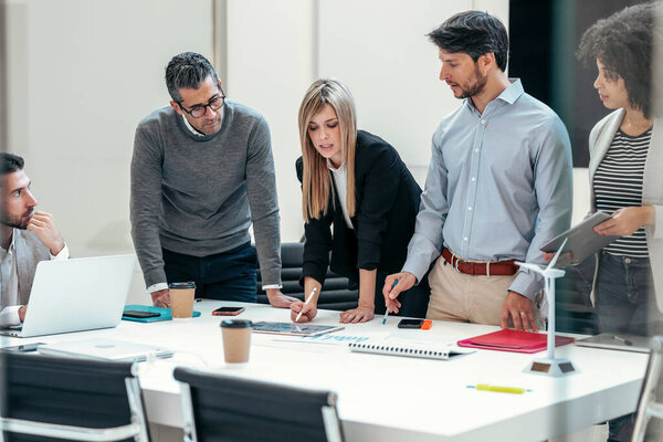 Shot of successful business team standing around computer for presentation of work in a modern startup.