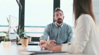 Modern bir ofiste bilgisayarla çalışırken akıllı iş ortaklarının konuştuğu bir video..