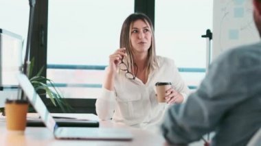 Modern bir ofiste bilgisayarla çalışırken akıllı iş ortaklarının konuştuğu bir video..