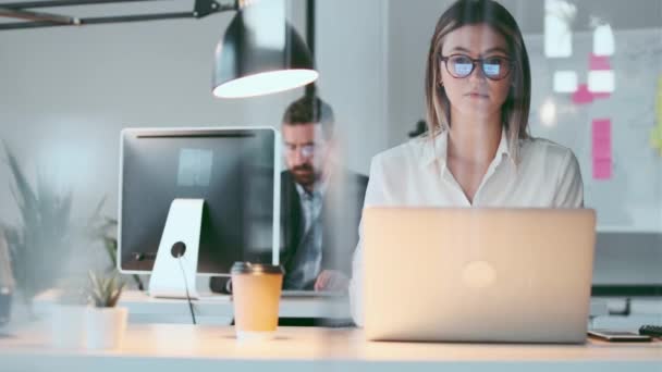 現代の新興企業のオフィスで同僚と頭痛を持っている間 ラップトップで働いている若いビジネスマンのビデオ — ストック動画