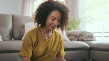 Evde, oturma odasında yerde otururken kredi kartıyla ödeme yapan bir kadının videosu..