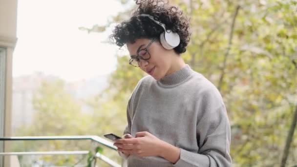 Video Vacker Kvinna Som Använder Sin Smartphone Medan Lyssnar Musik — Stockvideo