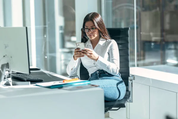 Modern Başlangıç Ofisinde Bilgisayarla Çalışırken Akıllı Telefonuyla Mesaj Gönderen Konsantre — Stok fotoğraf