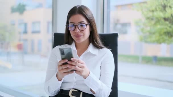 Video Wanita Terkonsentrasi Mengirim Pesan Dengan Smartphone Nya Saat Bekerja — Stok Video