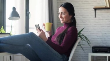 Güzellik sektörü kadınının evde çalışırken ve kahve içerken cep telefonuyla mesaj gönderdiği video..