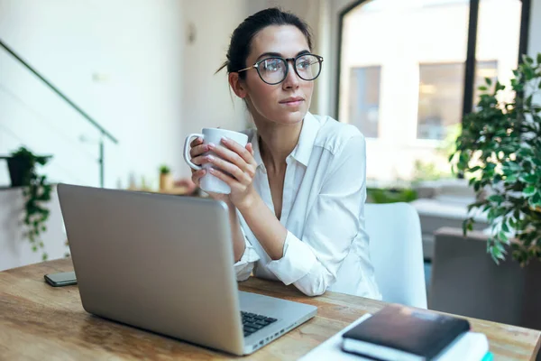 Tiro Mulher Bonita Trabalhando Com Laptop Enquanto Bebe Uma Xícara — Fotografia de Stock