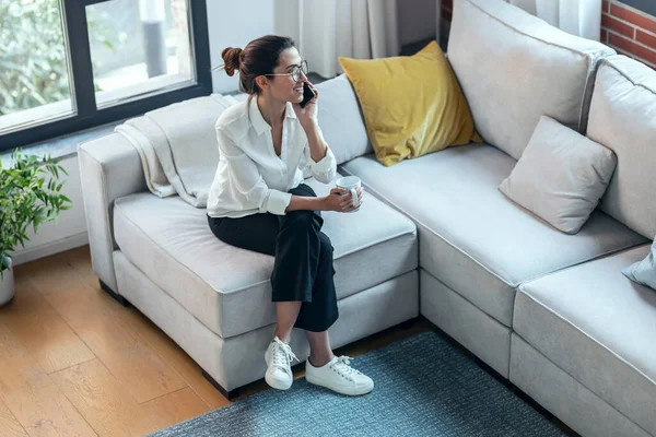 在家里沙发上喝咖啡的时候用手机拍的漂亮女人 — 图库照片