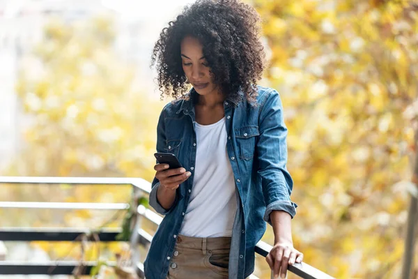 Foto Mujer Alegre Usando Teléfono Inteligente Mientras Envía Mensajes Pie — Foto de Stock