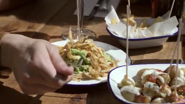 レストランでテラスで食べ物の異なるプレートを食べる友人のグループの終わりのビデオ — ストック動画
