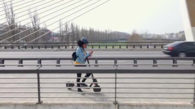 Caddede elektrikli puch scooter sürerken akıllı telefonuyla mesaj gönderen afro kadının videosu..