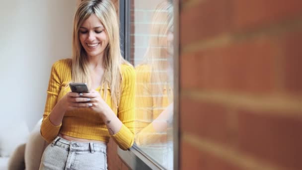 Video Mladé Ženy Pomocí Mobilního Telefonu Zatímco Stojí Okna Doma — Stock video