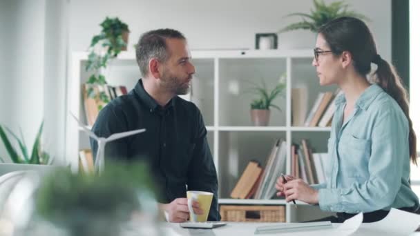 オフィスでコーヒーを飲みながら話をしている2人の賢い建築家のビデオ — ストック動画