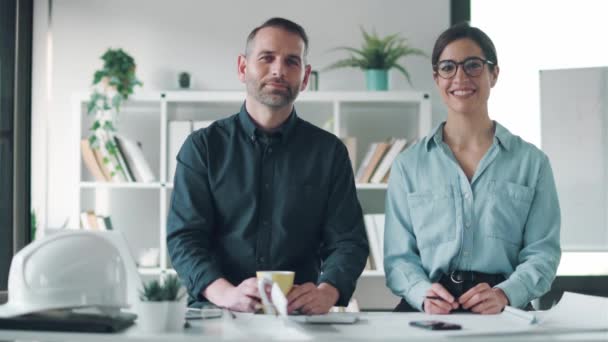 Vídeo Arquitetos Inteligentes Trabalhando Com Planos Enquanto Olha Para Câmera — Vídeo de Stock