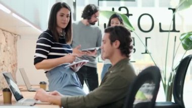 Birlikte çalıştıkları yeni projeden bahsederken bilgisayarlarla ve dijital tabletlerle çalışan çok ırklı iş adamlarının videosu.