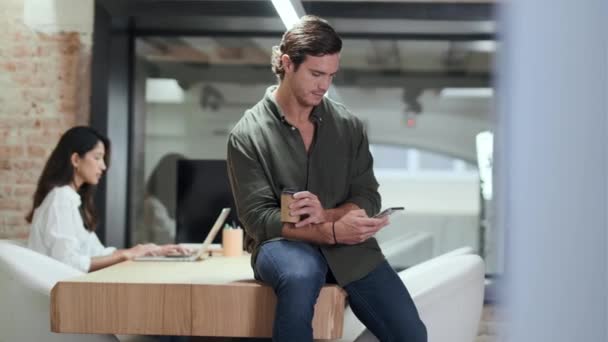 Video Zralého Podnikatele Pomocí Svého Smartphonu Zatímco Jeho Kolega Pracuje — Stock video
