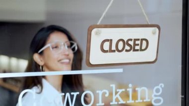 Dükkandaki cam kapıya açık tabelayı asan güzel bir genç kadının videosu..