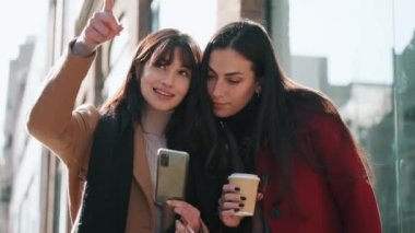 İki güzel turist arkadaşın sokakta akıllı bir telefondan online rehberine danışırken çekilmiş bir video..