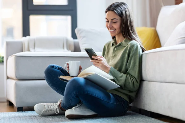 Tiro Mulher Muito Jovem Lendo Livro Enquanto Canta Telefone Celular — Fotografia de Stock