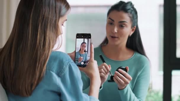 家庭でソーシャルメディアのビデオを作りながら化粧品について話す女性ブロガーのビデオを記録する女性のビデオ — ストック動画