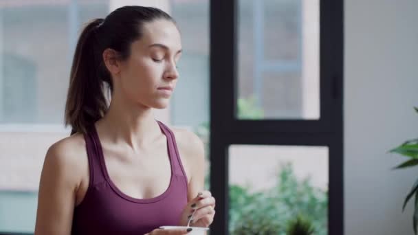 Video Sportliche Junge Frau Isst Joghurt Während Sie Hause Auf — Stockvideo