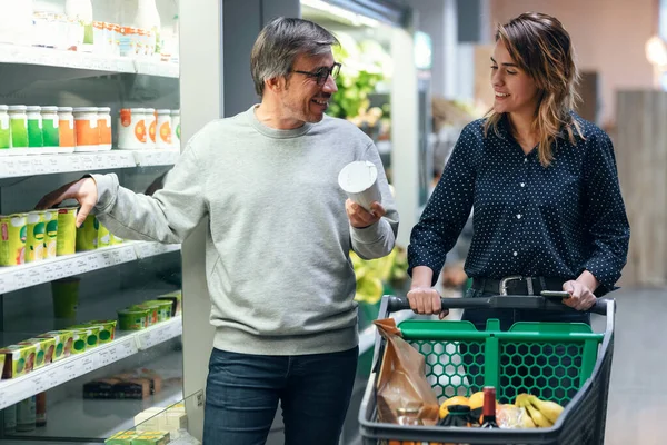 Tiro Casal Feliz Falando Enquanto Caminha Com Carrinho Compras Levando — Fotografia de Stock