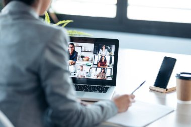 İş kadınlarının video görüşmesi ve evdeki kanepede otururken internet brifinginde başparmağını göstermesi..