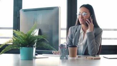 Ofiste bilgisayarla çalışan konsantre genç iş kadınının videosu..