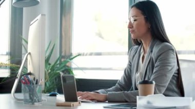 Ofiste bilgisayarla çalışırken başı ağrıyan yorgun iş kadınının videosu.