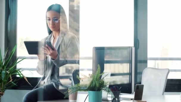現代のスタートアップオフィスの机の上に座っている間 彼女のデジタルタブレットを使用して美容ビジネス女性のビデオ — ストック動画