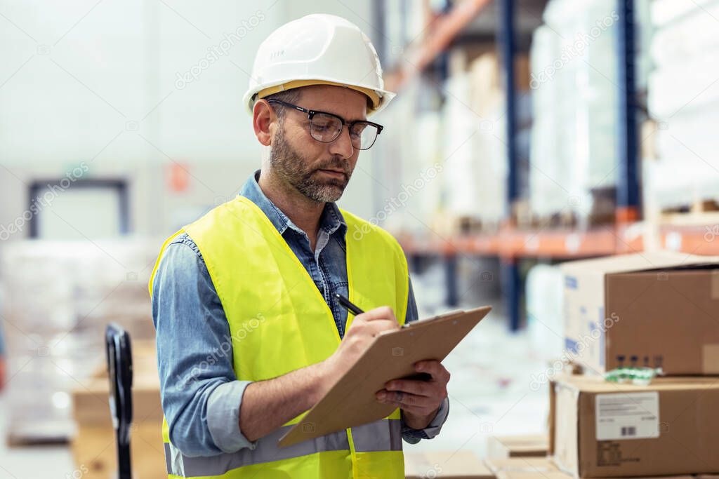 Shot of mature worker passing list of material that has arrived at the store warehouse.