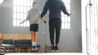 Spor salonunda idman yapan iki gencin videosu. Spor salonunda halatla atlarken..