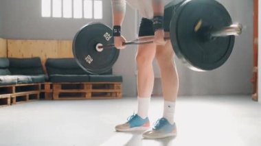 Sporcunun kafasının üstünde halterle çömelme videosu. Crossfit spor salonunda egzersiz yaparken..