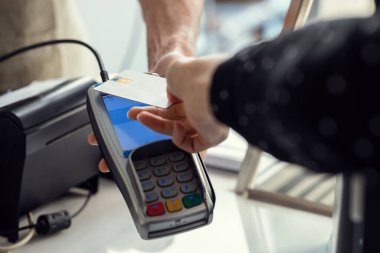 Restoranda elektronik okuyucuya ödeme yapmak için kredi kartını kullanan müşteriyi kapat..