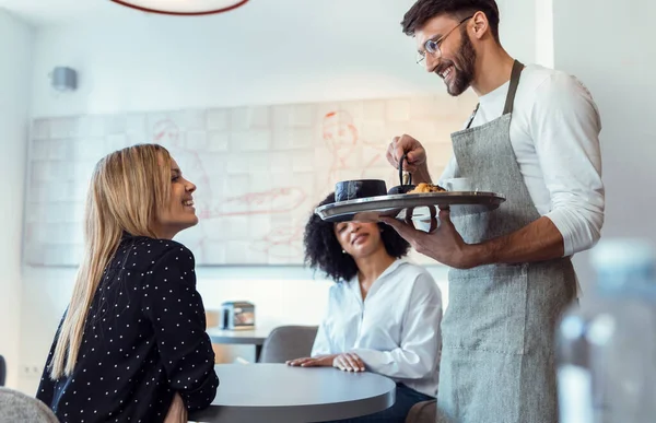 Shot Handsome Waitress Man Serving Coffee Pastry Smiling Women Table — Foto Stock