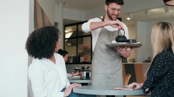 Video Handsome Waitress Man Serving Coffee Pastry Smiling Women Table — Stockvideo