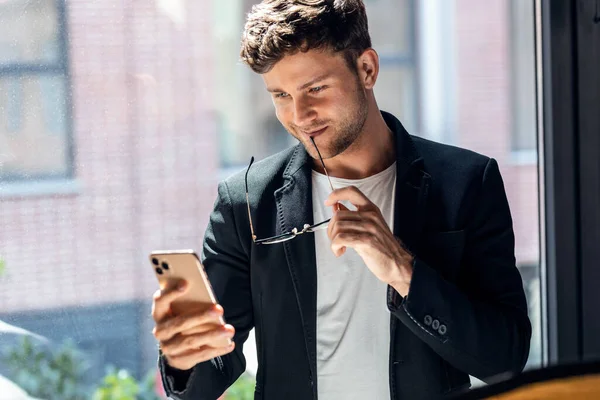 Shot Elegant Businessman Reading Messages While Using Smartphone Standing Window — Stockfoto