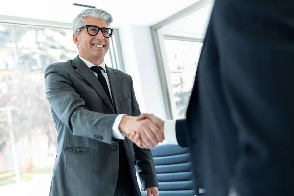 現代のスタートアップオフィスで新しい契約を締結した後笑顔で手を振るビジネスの人々のショット — ストック写真