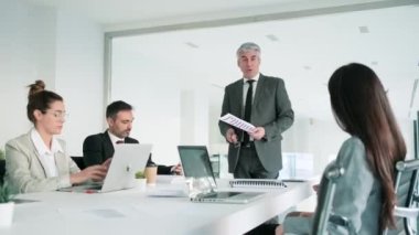 Modern bir girişimde iş konuşmak için toplantı yapan başarılı bir iş ekibinin videosu..