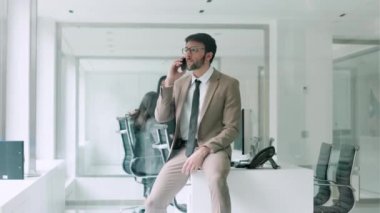 Modern bir girişimde ofisinin penceresinin yanında duran genç işadamının cep telefonuyla konuştuğu bir video..