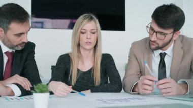 Modern başlangıçtaki toplantıda iş arkadaşlarıyla konuşurken çalışan akıllı iş ekibinin videosu. 