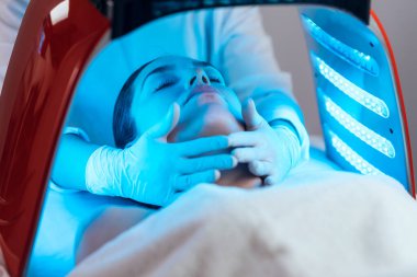 Kozmetik uzmanı ultrasonik temizlik ve gençleştirme yapıyor. Spa merkezindeki güzel bir kadının yüzü..