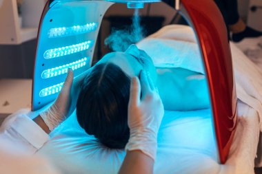 Kozmetik uzmanı ultrasonik temizlik ve gençleştirme yapıyor. Spa merkezindeki güzel bir kadının yüzü..