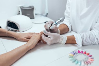 Salonda sürekli manikür yapan genç bir kadının yakın çekimi. Güzellik konsepti.