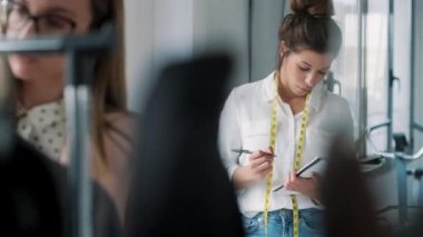 İki moda tasarımcısının çalıştığı ve dikiş atölyesindeki yeni kıyafet koleksiyonunun detaylarına karar verdikleri video..