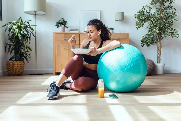 Tiro Mujer Joven Deportiva Comiendo Sano Mientras Escucha Música Sentada — Foto de Stock