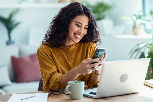 Snímek Krásné Mladé Ženy Pomocí Mobilního Telefonu Při Práci Notebookem — Stock fotografie